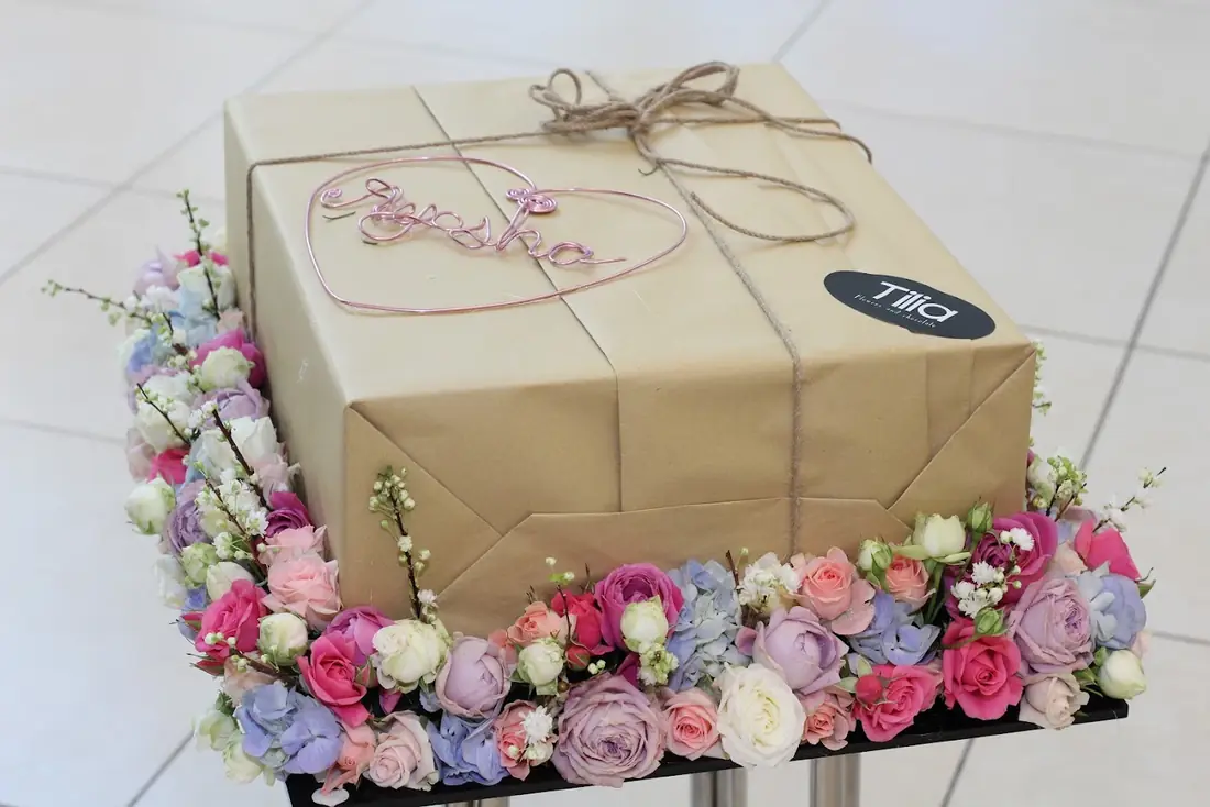 A ring of white flowers around a wrapped gift