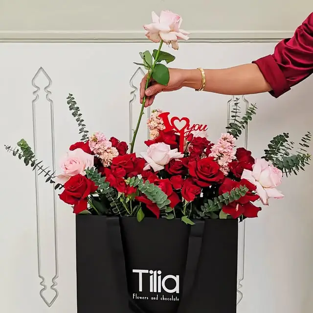 Red roses in a black Tilia bag