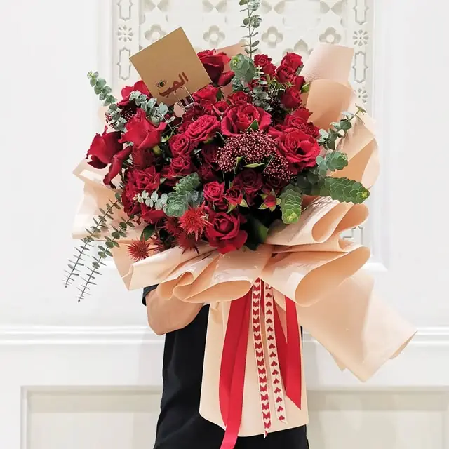 A bouquet of red roses held in the shop