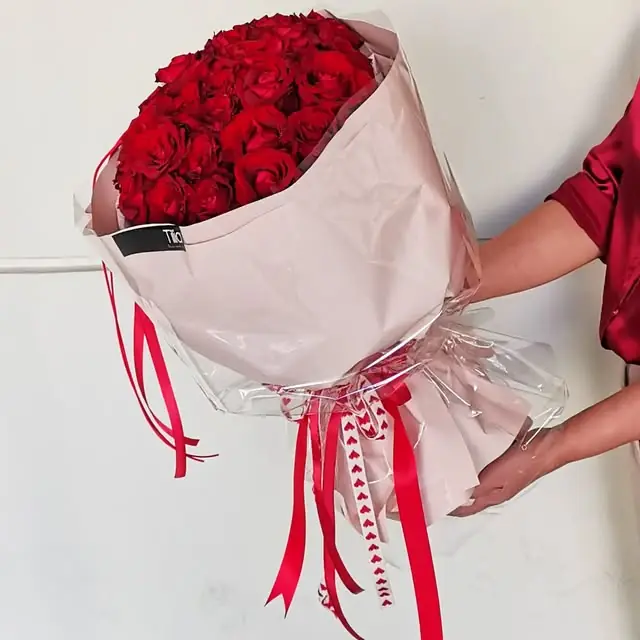 Red roses wrapped in pink with red ribbons