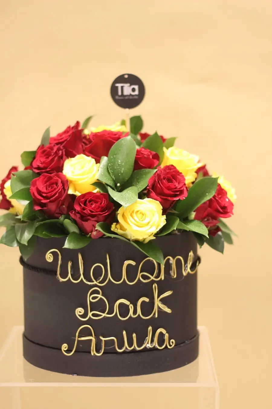 A Welcome Back Arusa topper in gold wire over pink and white flowers